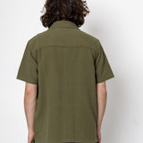 Person wearing an olive green shirt against a white background