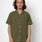 Man wearing an olive green short-sleeve shirt against a white background