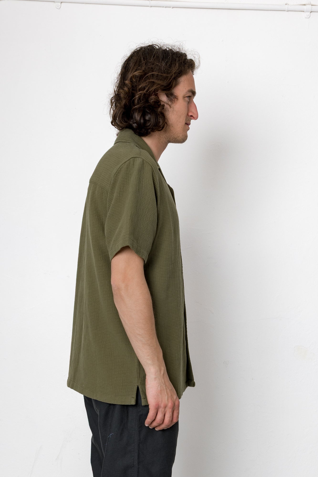 Man wearing an olive green shirt against a white background