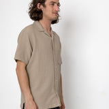 Man wearing a beige shirt against a white background