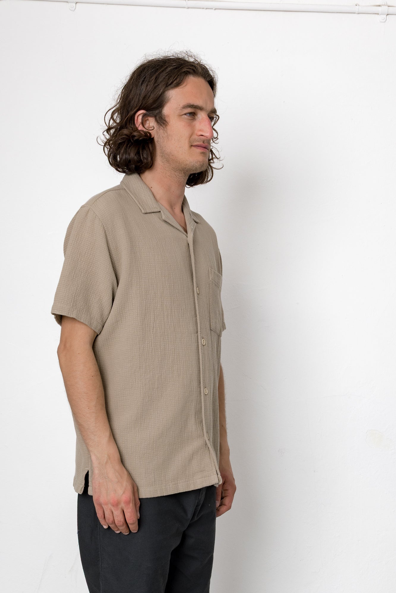 Man wearing a beige shirt against a white background