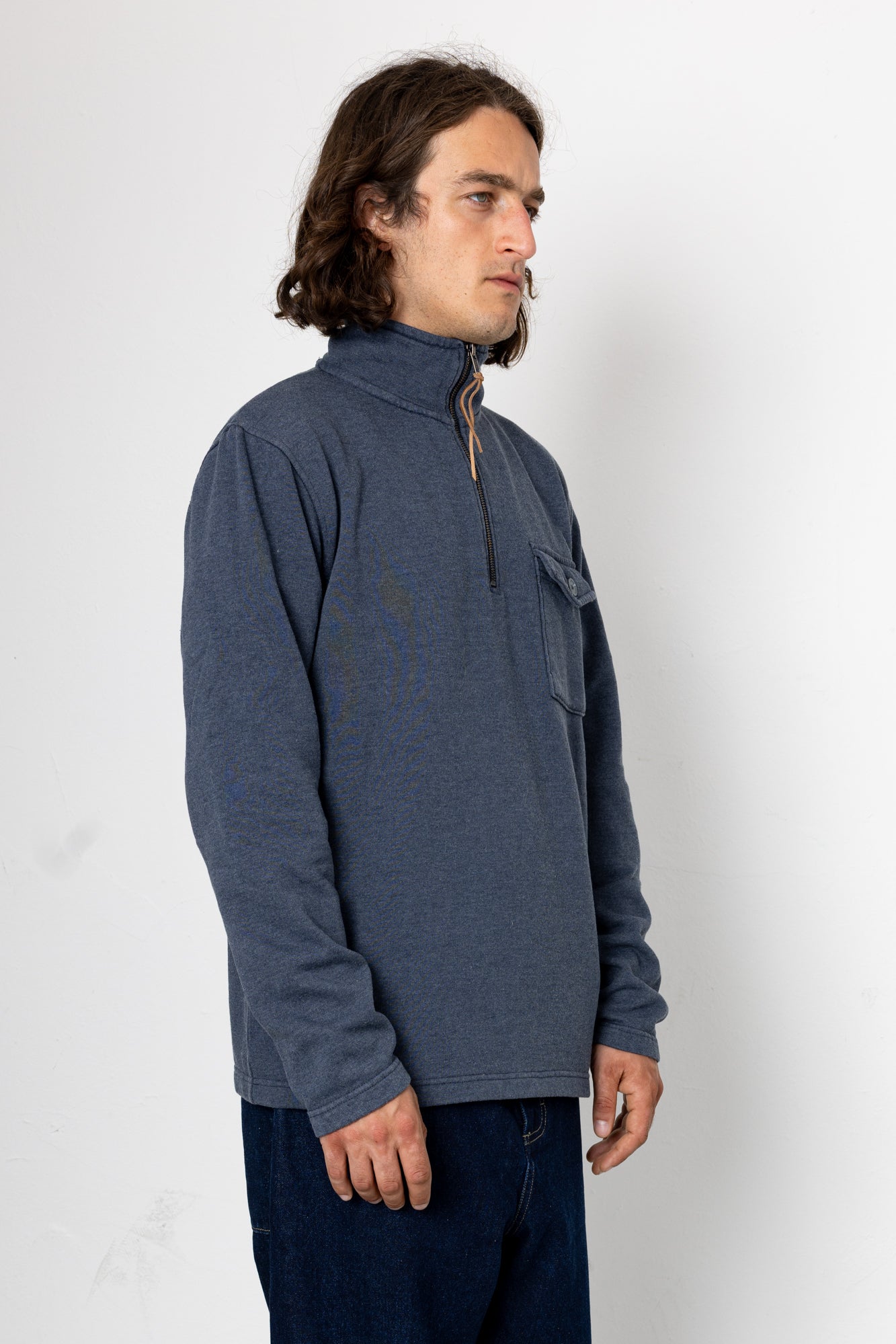 Man wearing a blue pullover with a zipper on a white background