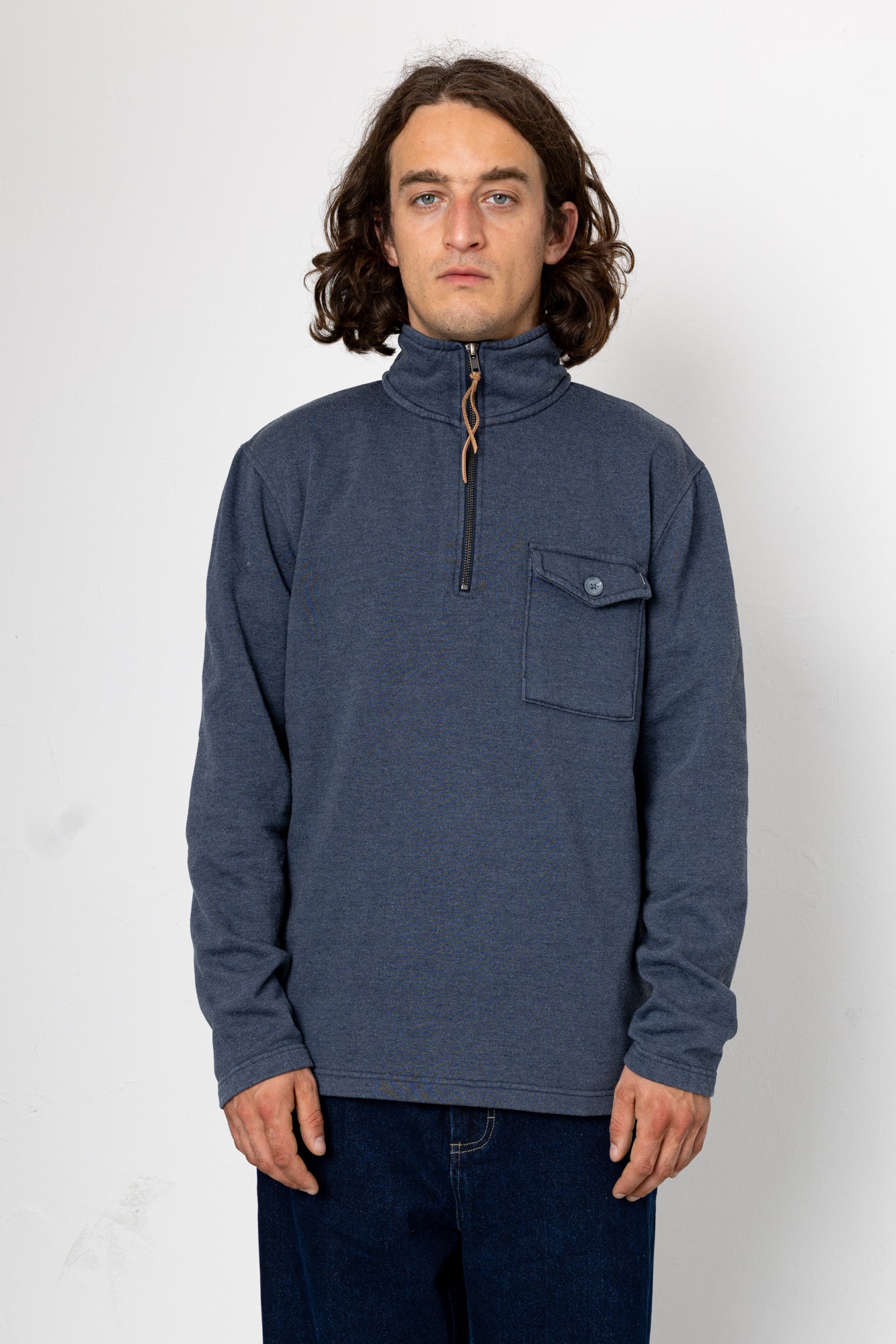 Man wearing a blue pullover with a pocket on a white background