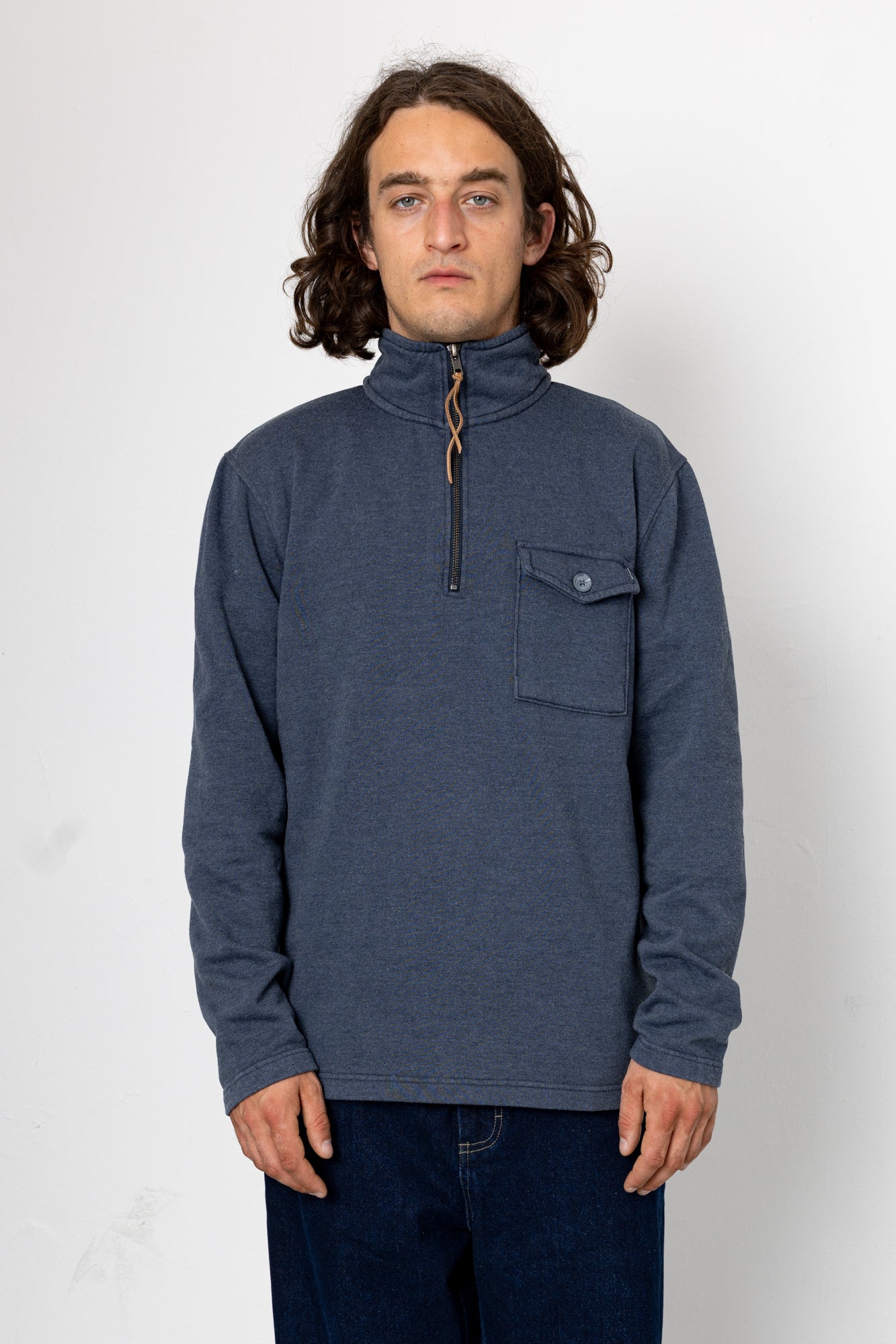 Man wearing a blue pullover with a zipper on a white background