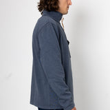 Person wearing a blue jacket against a white background