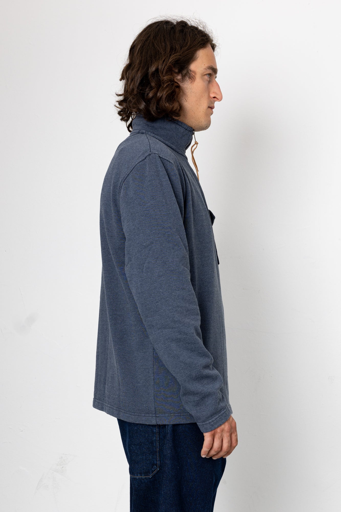 Person wearing a blue jacket against a white background