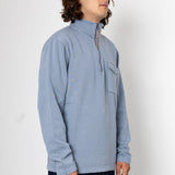 Man wearing a light blue pullover with a zipper on a white background