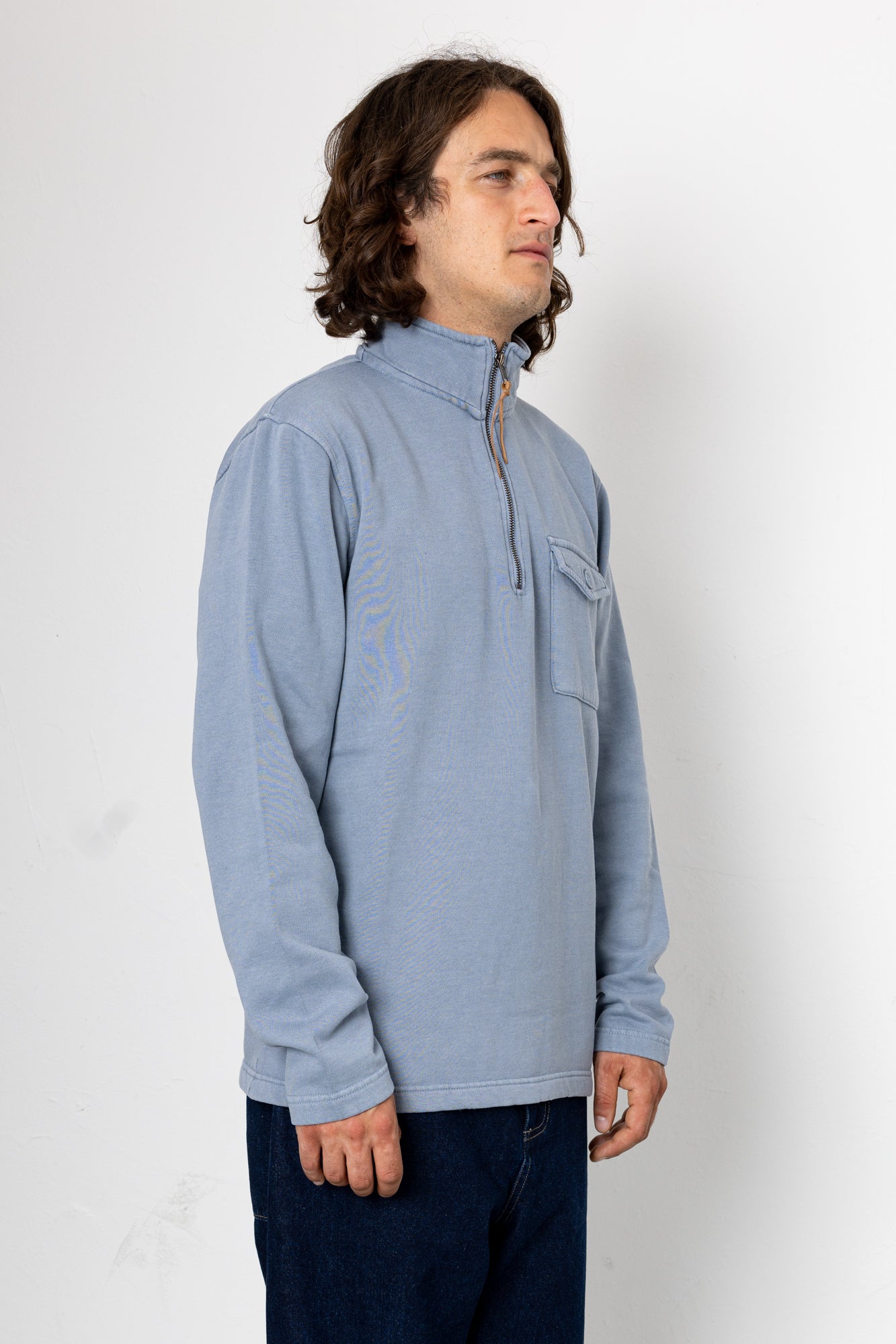 Man wearing a light blue pullover with a zipper on a white background