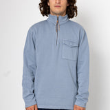 Man wearing a light blue pullover with a pocket on a white background