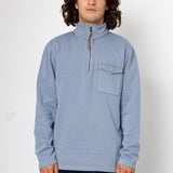 Man wearing a light blue pullover with a pocket on a white background