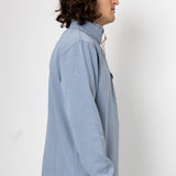 Person wearing a light blue pullover against a white background
