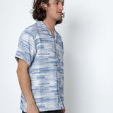Man wearing a blue patterned shirt against a white background