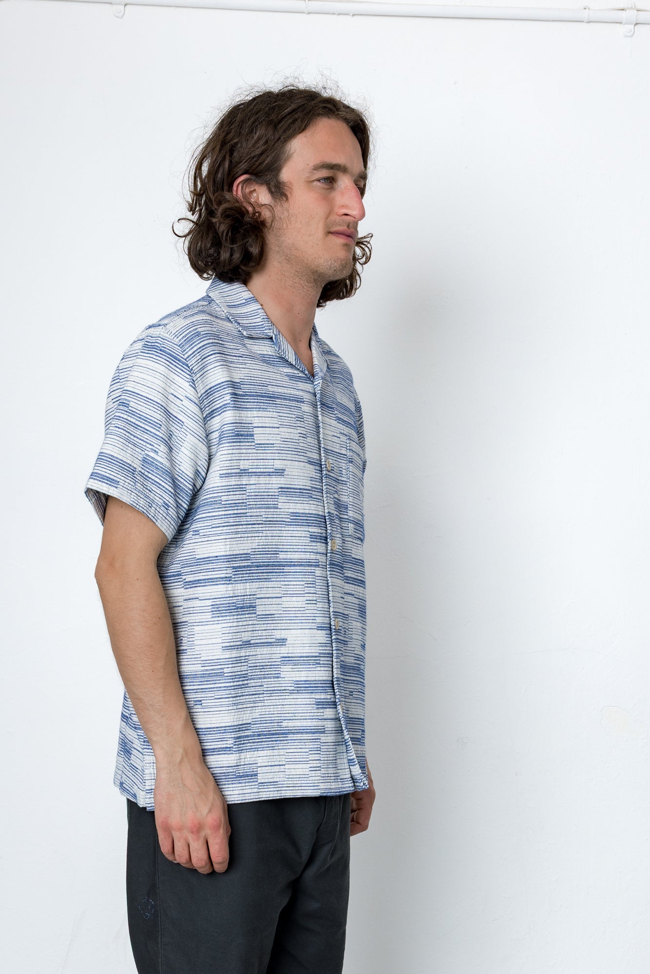 Man wearing a blue patterned shirt against a white background