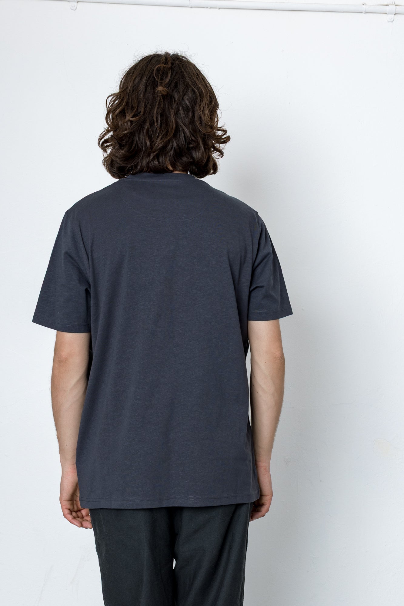 Person wearing a dark gray t-shirt against a white background