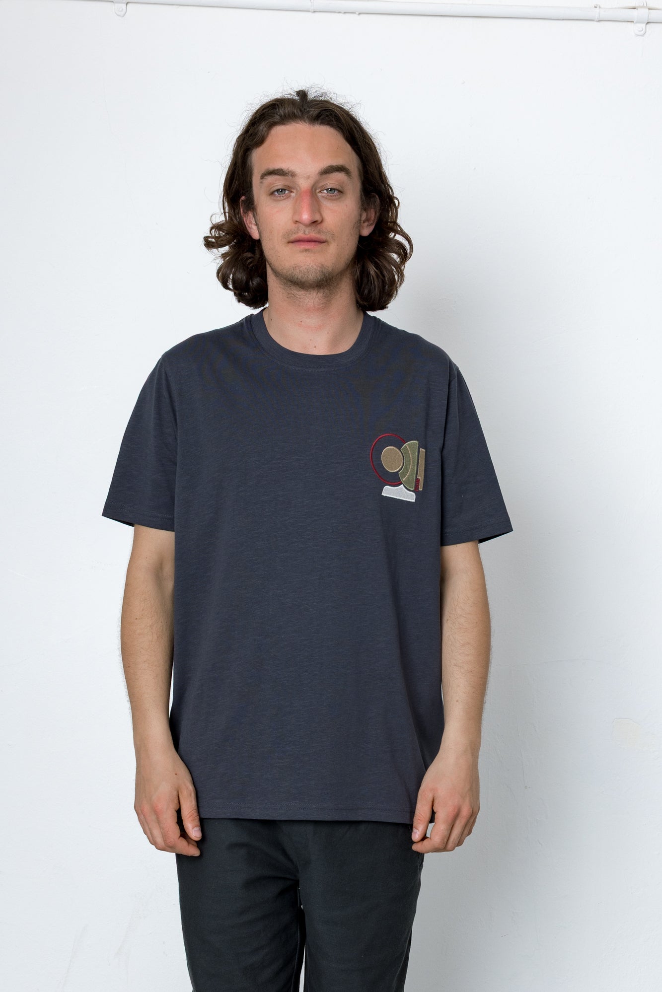 Person wearing a navy blue t-shirt with a small graphic on a white background