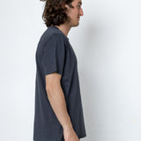 Man wearing a dark gray t-shirt and pants against a white background