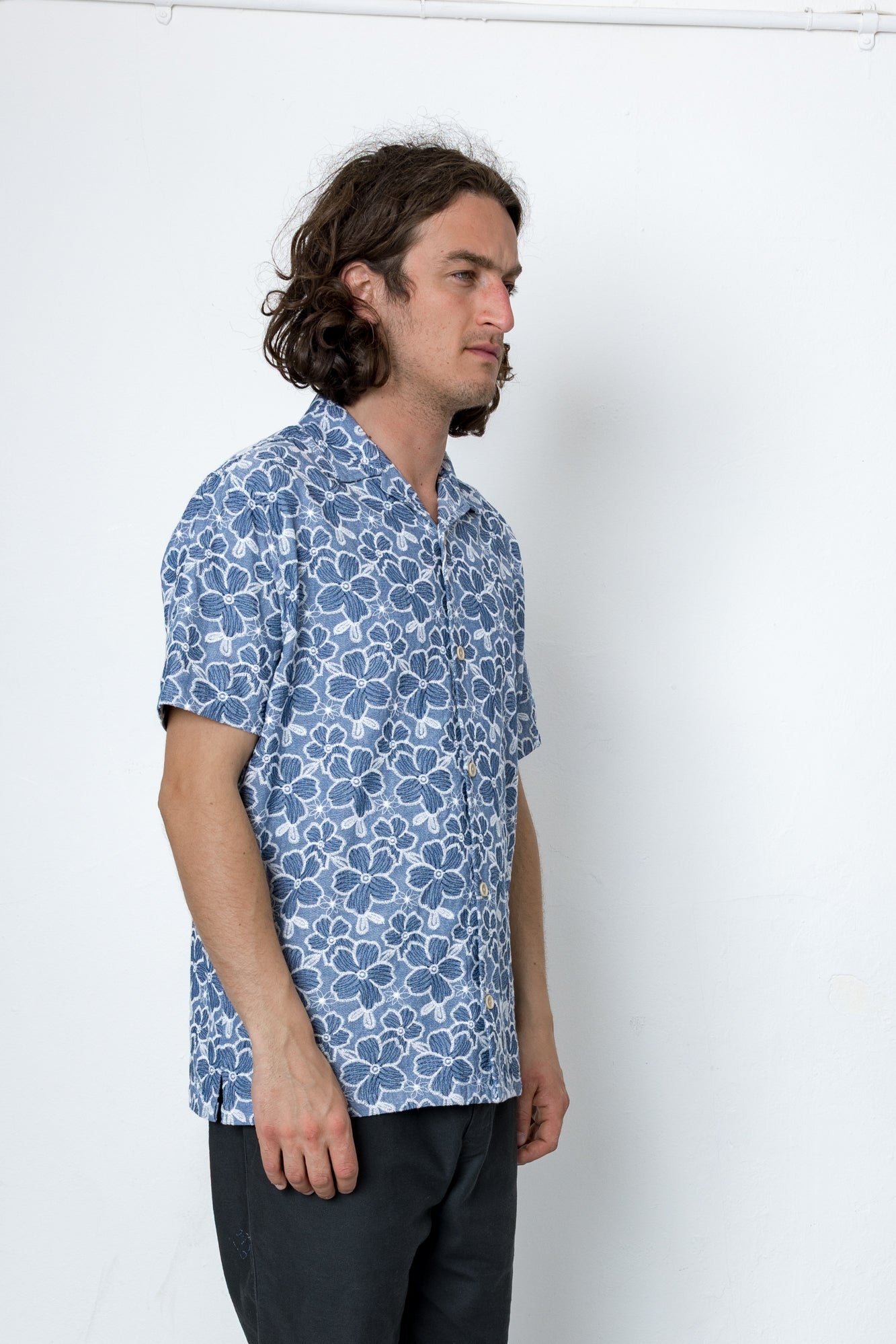 Man wearing a blue patterned shirt against a white background