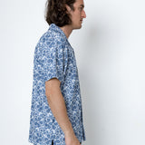 Man wearing a blue patterned shirt against a white background