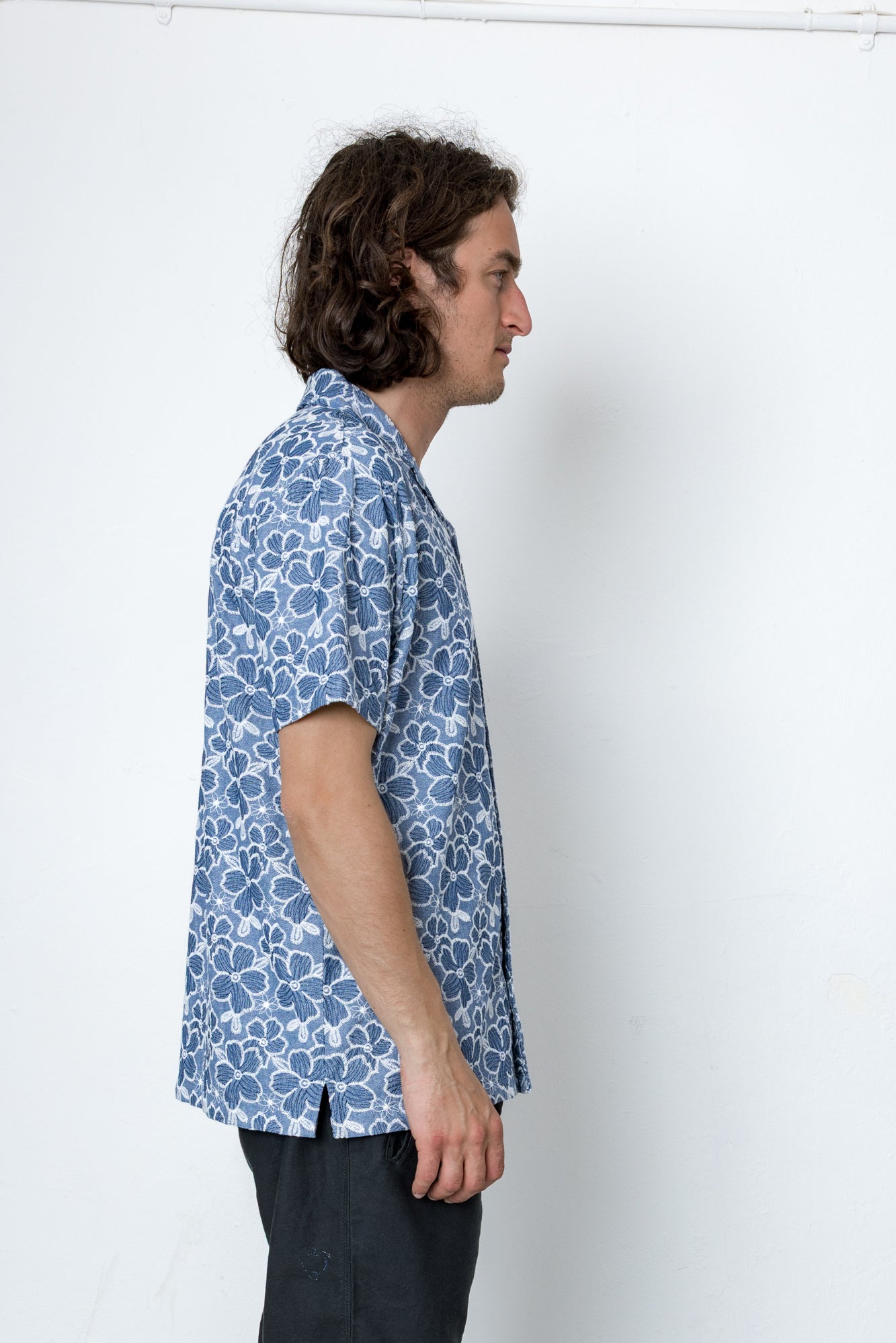 Man wearing a blue patterned shirt against a white background