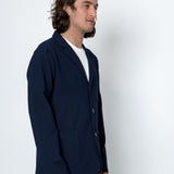 Man wearing a navy blazer and white t-shirt