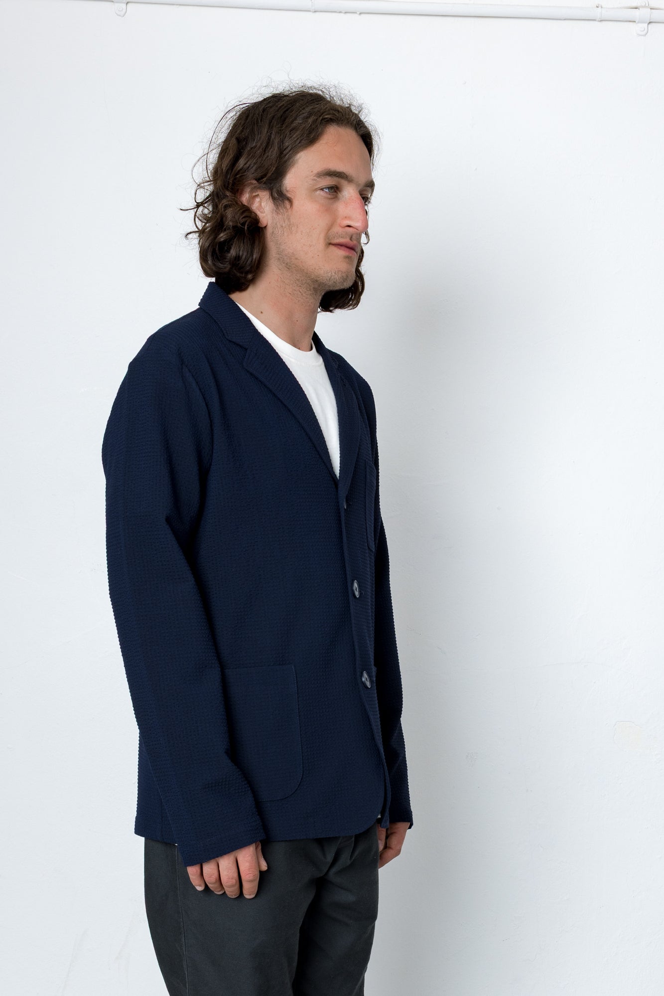 Man wearing a navy blazer and white t-shirt