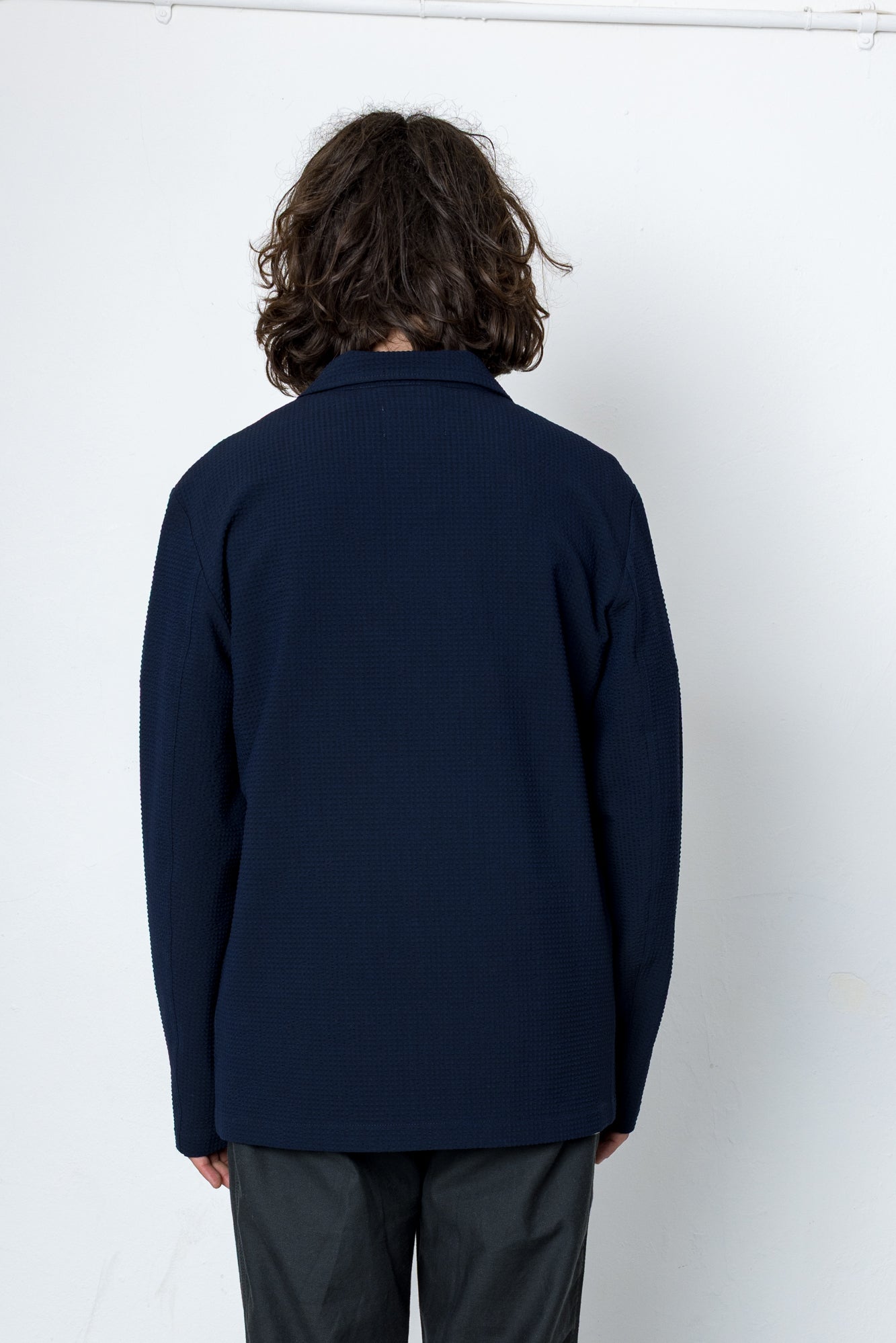 Person wearing a navy blue jacket against a white background