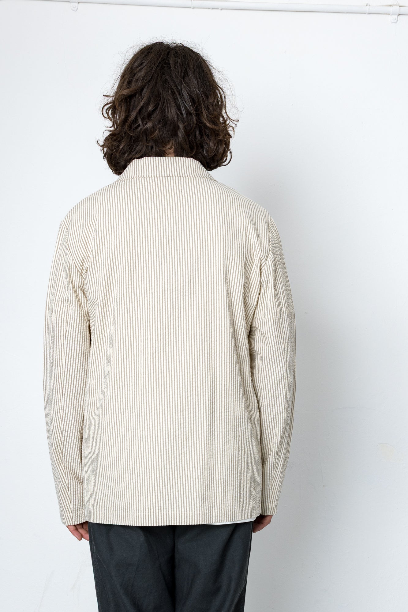 Back of a man wearing a striped beige blazer