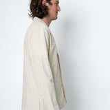 Man wearing cream blazer standing side-on