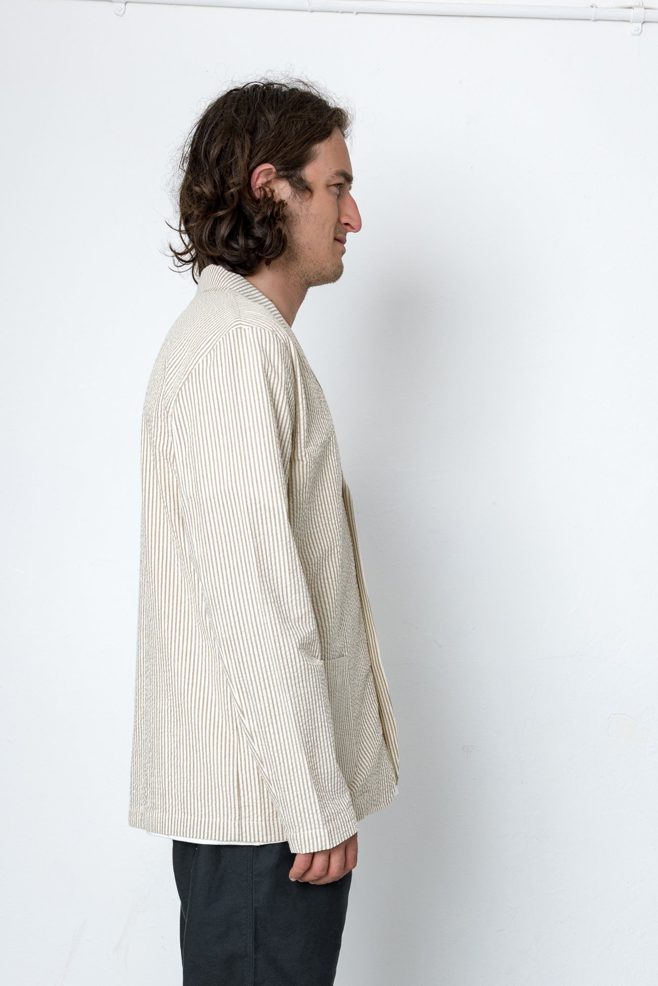 Man wearing cream blazer standing side-on