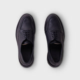 A pair of dark navy blue leather lace-up dress shoes shown from a top-down view on a light gray background.