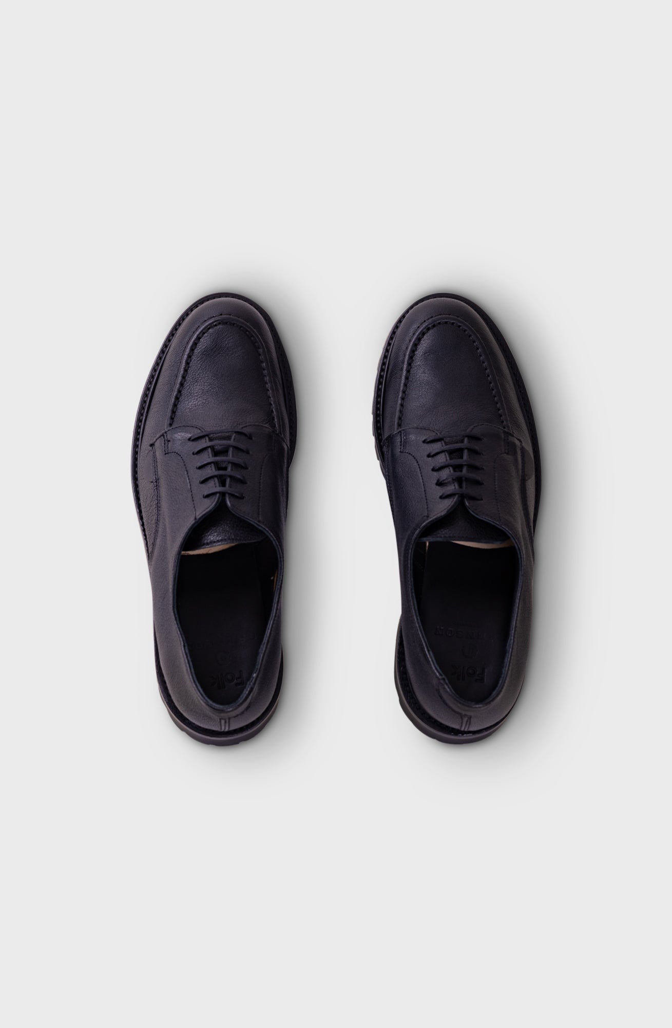 A pair of dark navy blue leather lace-up dress shoes shown from a top-down view on a light gray background.