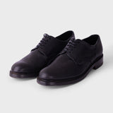 Black sneakers with white soles on a light gray background
