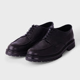 Black sneakers with white accents on a light gray background