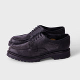 A pair of dark navy blue leather lace-up shoes with thick lug soles, displayed on a light gray background.