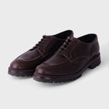 A pair of dark brown leather lace-up shoes with a rugged lug sole, displayed on a light gray background.