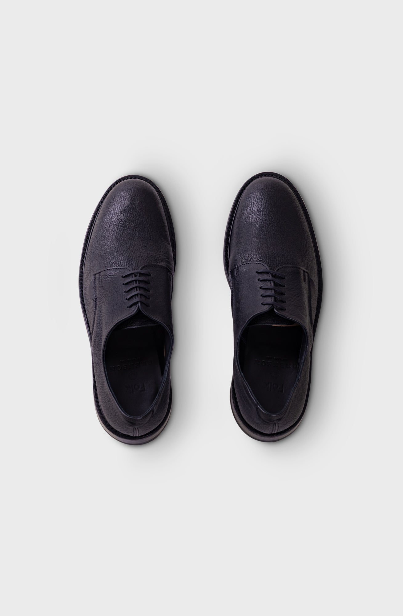 A pair of dark navy blue leather oxford shoes shown from a top-down view on a light gray background.
