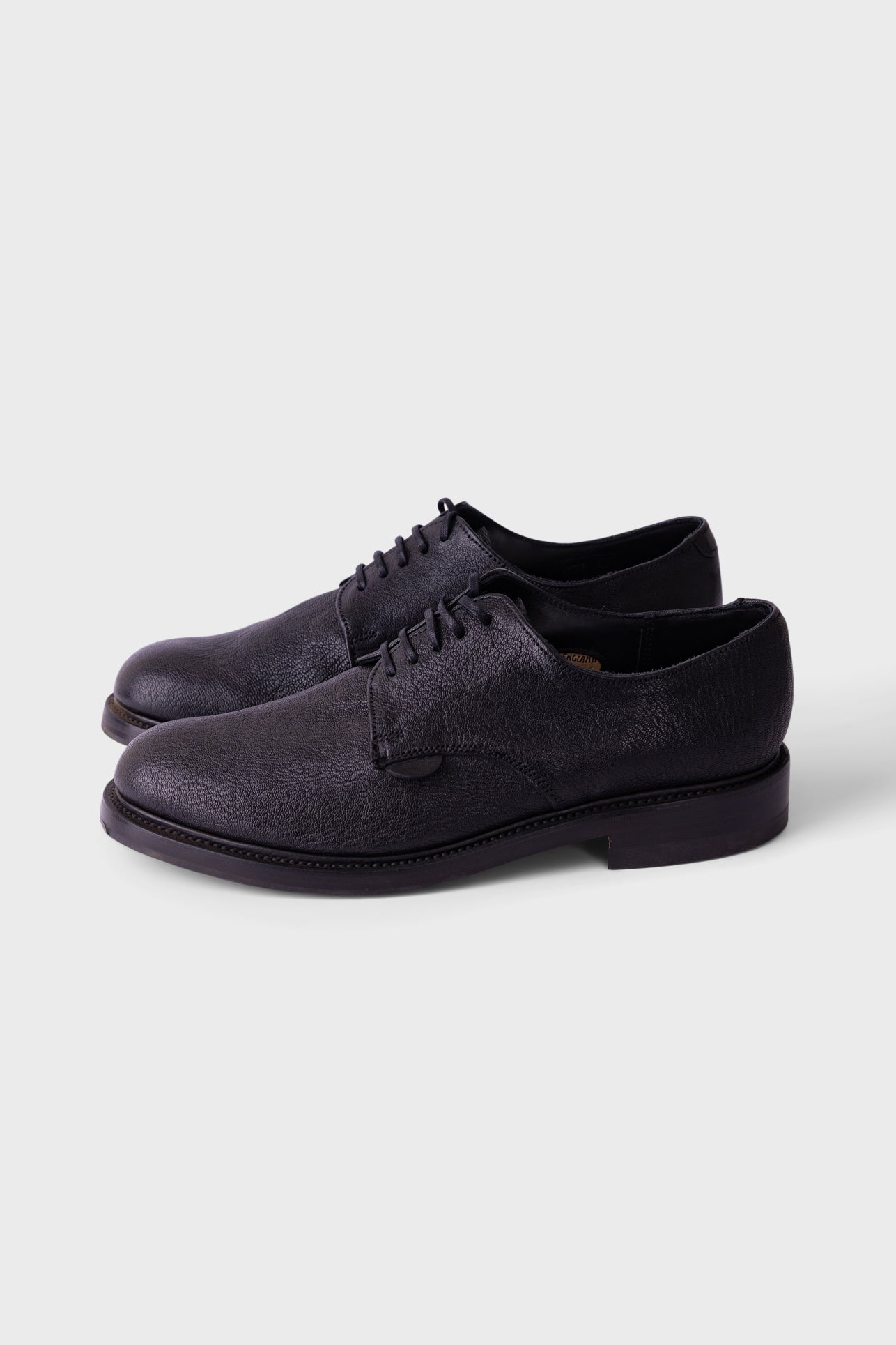 Black soccer cleat on a white background