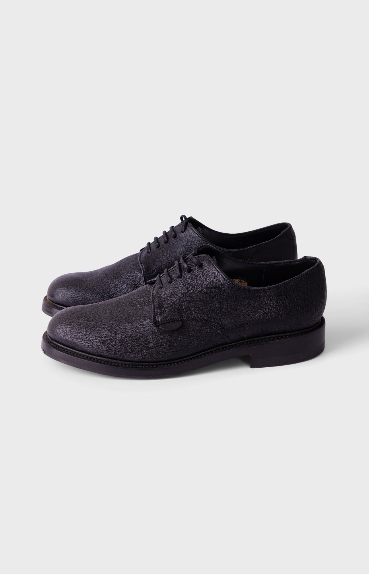 Black soccer cleat on a white background