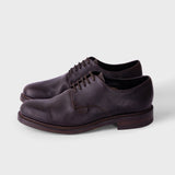 A single black slip-on shoe with a textured knit upper and a thick, flexible sole, shown from a side profile on a white background.