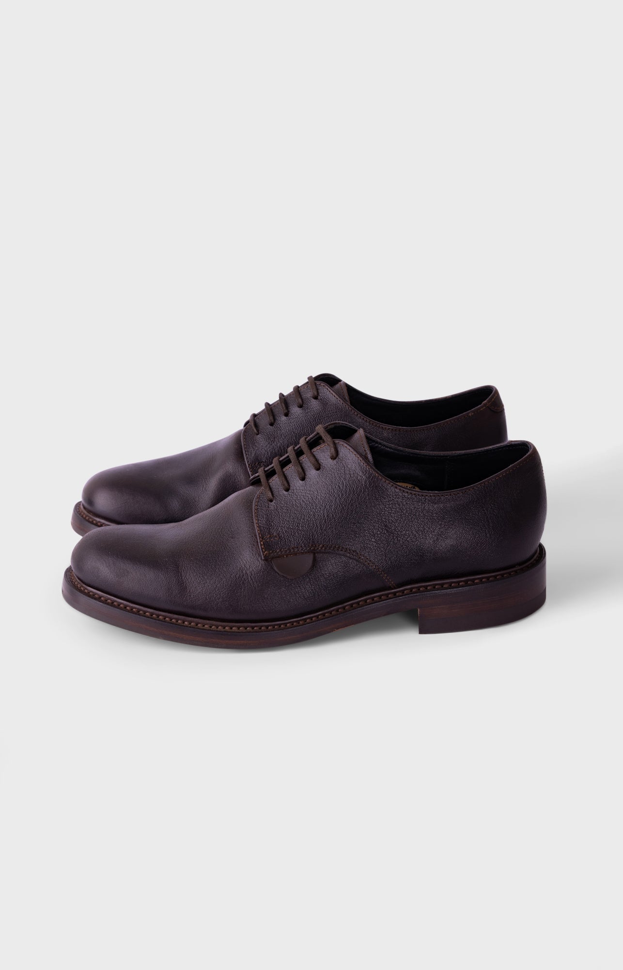A single black slip-on shoe with a textured knit upper and a thick, flexible sole, shown from a side profile on a white background.