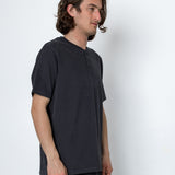 Man wearing a dark gray t-shirt and pants against a white background