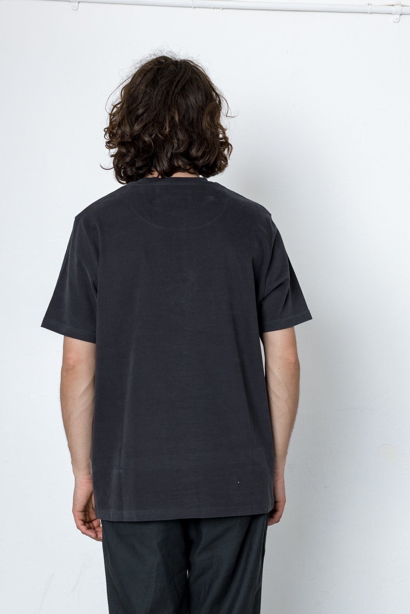 Person wearing a black t-shirt and pants against a white background