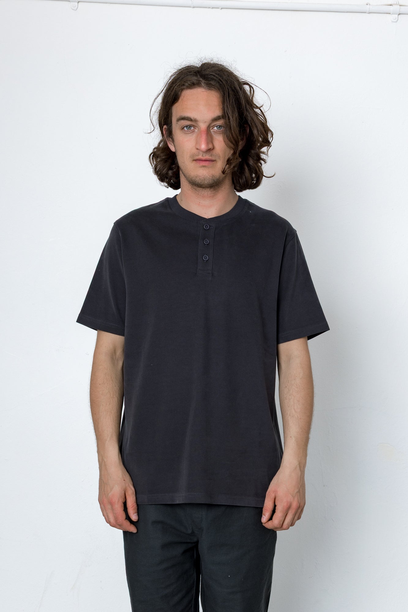 Man wearing a black t-shirt and pants against a white background