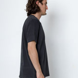 Man wearing a dark gray t-shirt against a white background