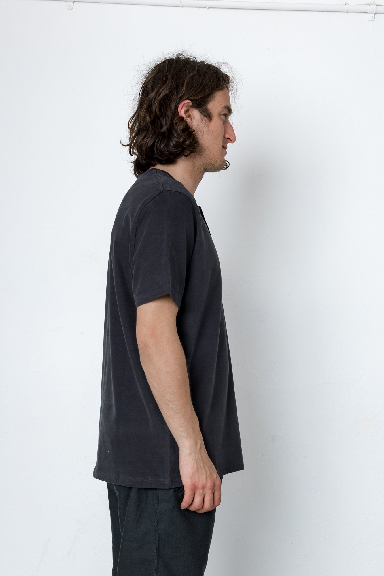 Man wearing a dark gray t-shirt against a white background