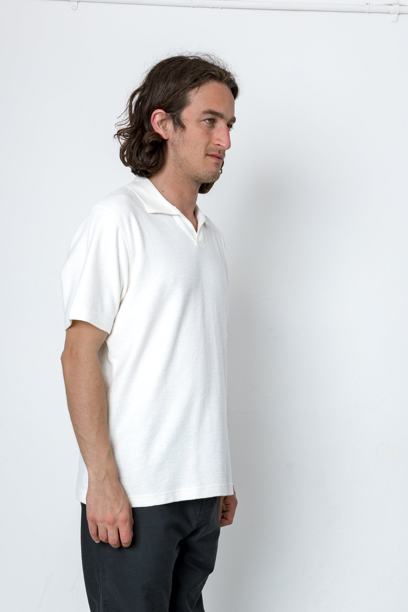 Man wearing a white polo shirt against a white background