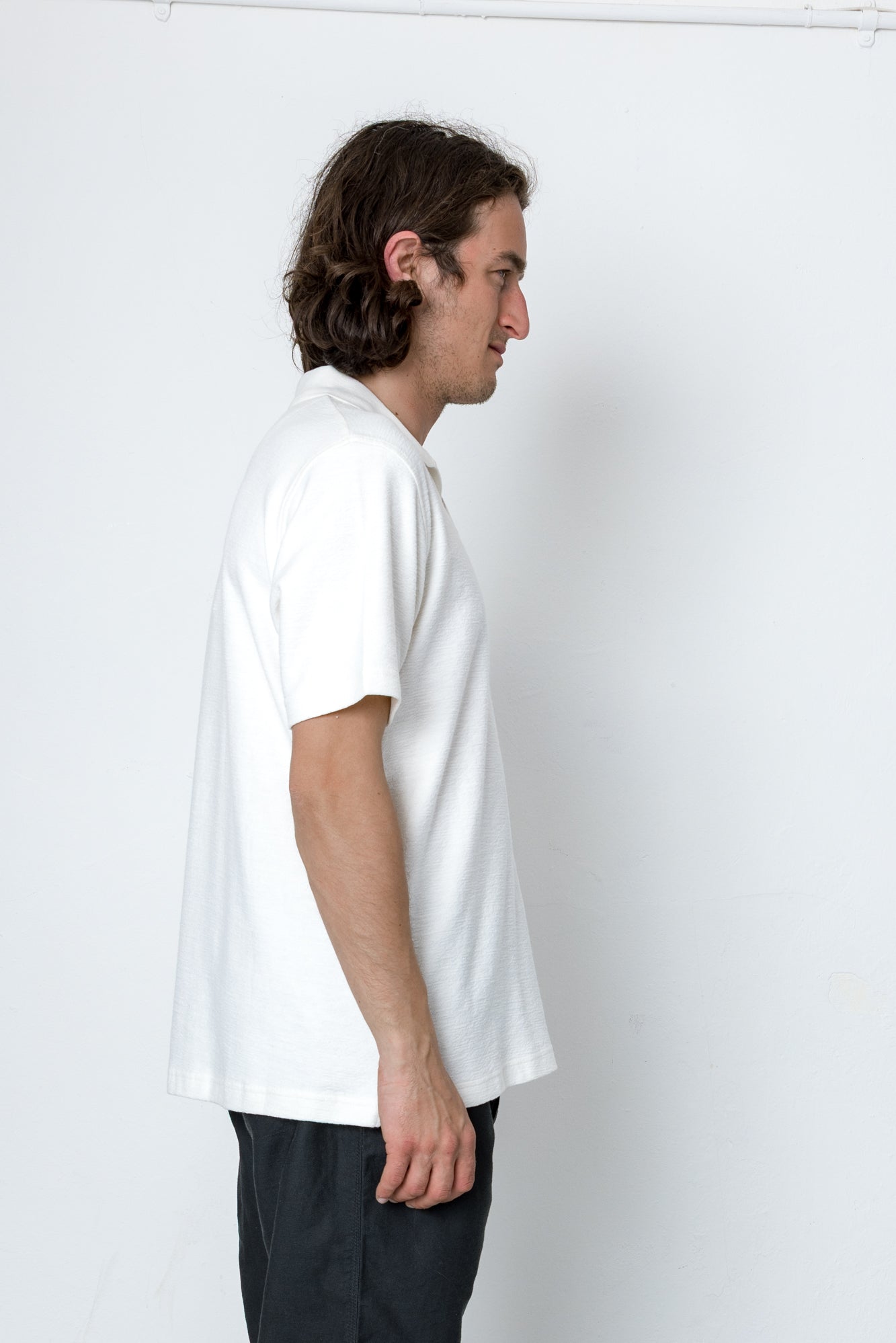 Person wearing a plain white t-shirt against a white background