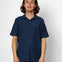 Man wearing a navy blue polo shirt against a white background