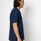 Man wearing a navy blue shirt against a white background