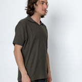 Man wearing a green polo shirt against a white background